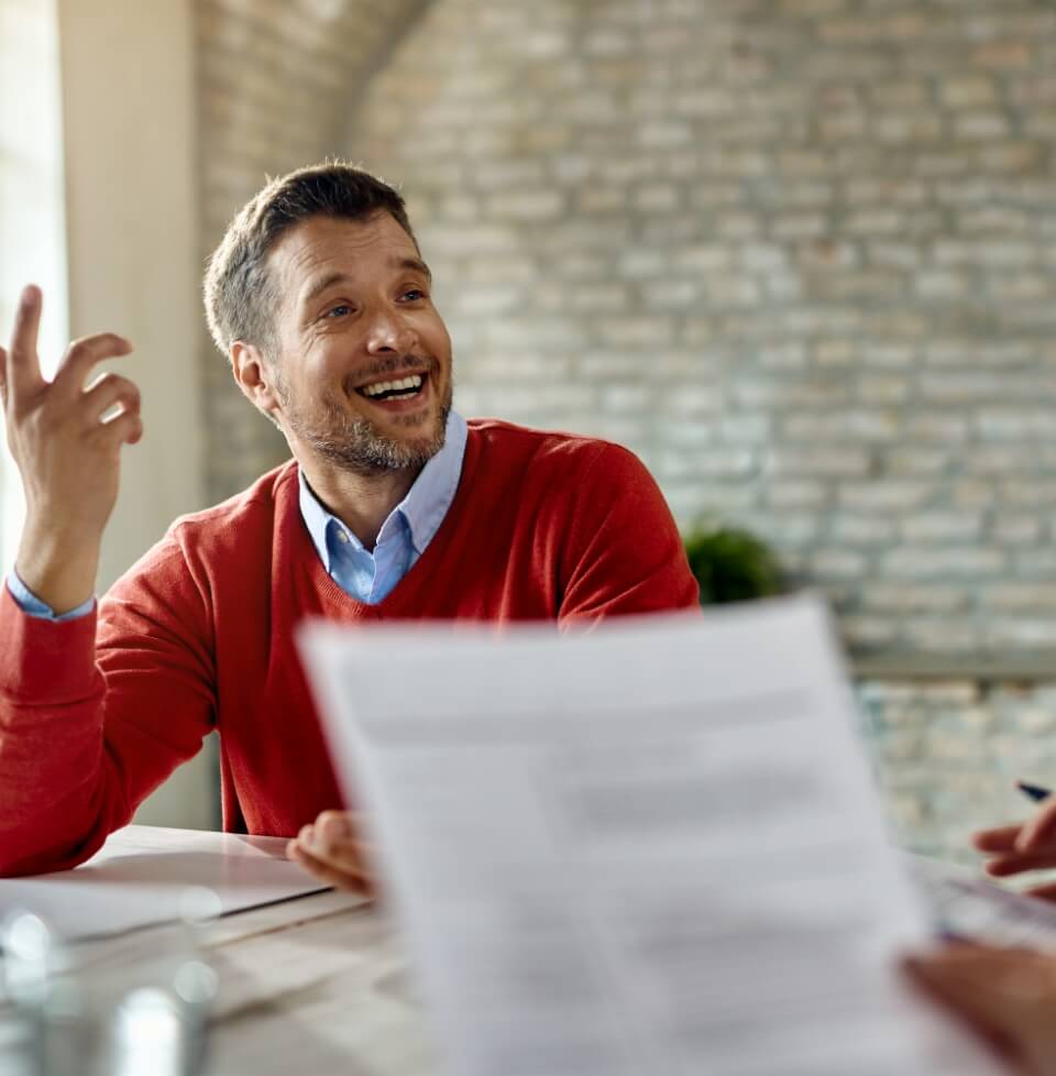 happy-male-candidate-communicating-with-member-human-resource-team-during-job-interview-office