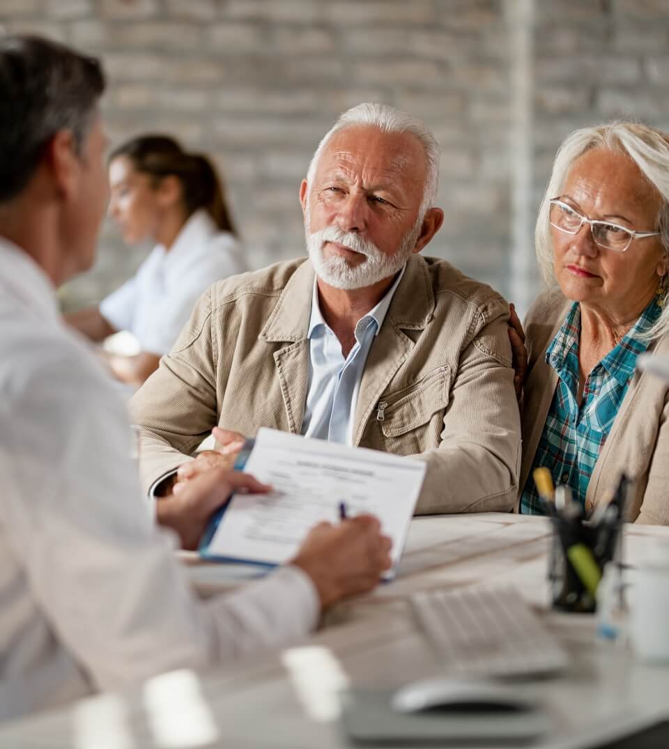 senior-couple-consulting-with-healthcare-worker-about-their-insurance-policy-while-having-meeting-clinic