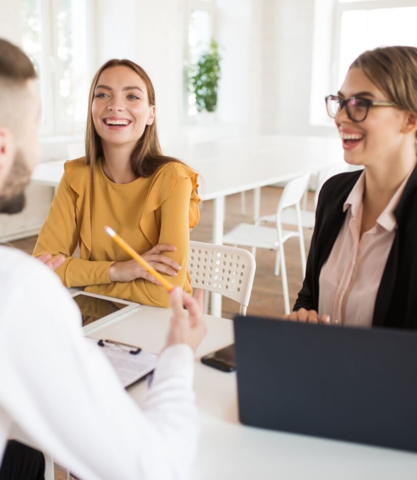 two-beautiful-business-women-happily-talking-with-male-applicant-work-young-smiling-employers-spending-job-interview-modern-office